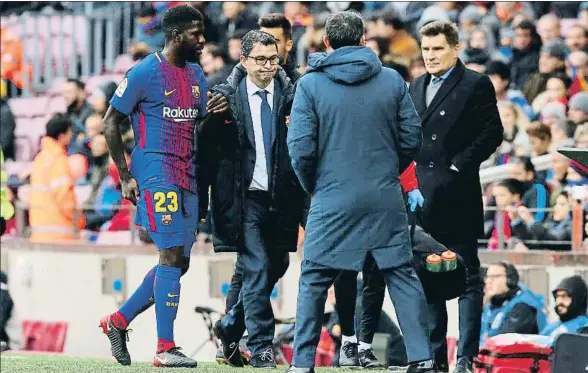  ?? ALBERT GEA / REUTERS ?? Samuel Umtiti, con la mano sobre la zona lesionada, se retira a los vestuarios acompañado del doctor Ricard Pruna