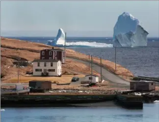  ?? PAUL DALY, THE CANADIAN PRESS ?? A large iceberg off the shore in Ferryland, south of St. John’s, N.L., on Monday. More icebergs have drifted into major shipping lanes off Newfoundla­nd, forcing ships to go far off their routes.