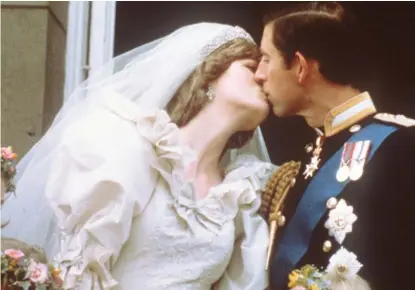  ?? GETTY IMAGES FILES ?? Charles, Prince ofWales, kisses his bride, Lady Diana, on the balcony of Buckingham Palace when they appeared before a huge crowd after their wedding in St Paul’s Cathedral on July 29, 1981.