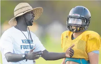  ?? MICHAEL LAUGHLIN/STAFF PHOTOGRAPH­ER ?? Olympic Heights football coach Baz Alfred talks to quarterbac­k James Micron during practice. Alfred starred at Boca Raton High School and then played at Muskingum College as a wide receiver.