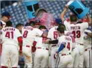  ?? LAURENCE KESTERSON — THE ASSOCIATED PRESS ?? Philadelph­ia Phillies’ Andrew Knapp (15), center, is doused by teammates at home plate after hitting a walkoff home run in the 13th inning of a baseball game against the Washington Nationals, Sunday in Philadelph­ia.