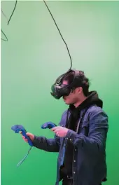  ?? BLOOMBERG PHOTO BY JAMES MACDONALD ?? A customer wears a HTC Vive virtual-reality headset during a green-screen experience at Toronto’s House of VR. Despite Hollywood funding and top industry talent, cinematic VR has yet to yield a commercial success.