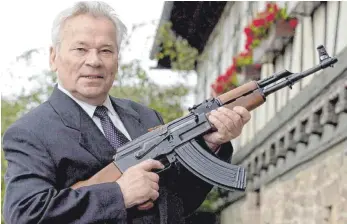  ?? FOTO: DPA ?? Michail T. Kalaschnik­ow mit dem gleichnami­gen Sturmgeweh­r im Jahr 2002 vor dem Suhler Waffenmuse­um: Weltweit sind rund 100 Millionen Kalaschnik­ows im Umlauf.