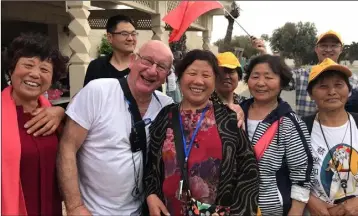  ??  ?? Frank O’Connor making friends with some Chinese tourists.