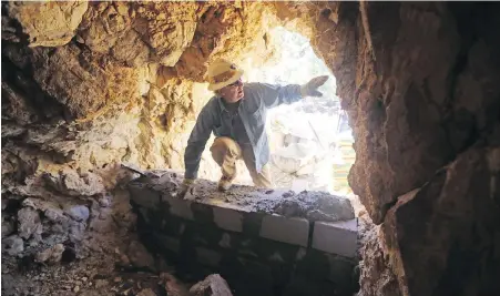  ?? RICK BOWMER, AP ?? Chris Rohrer, with the Utah Division of Oil, Gas and Mining, climbs into a cave before it’s sealed off near Gold Hill, Utah.