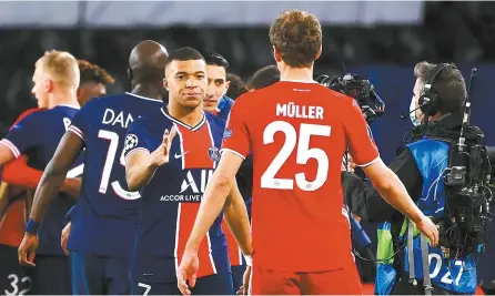 ?? AFP-Yonhap ?? Paris Saint-Germain’s Kylian Mbappe, left, shakes hands with Bayern Munich’s Thomas Mueller after PSG won the Champions League quarterfin­al at the Parc des Princes stadium in Paris, Tuesday.