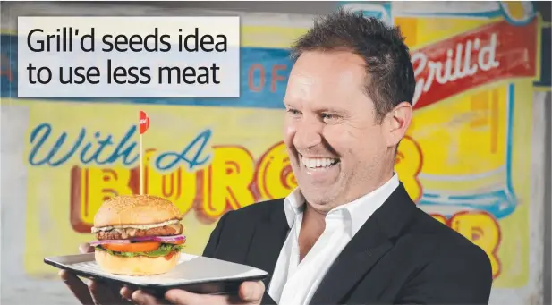  ?? Picture: ANDREW HENSHAW ?? VEGING OUT: Grill'd founder Simon Crowe checks out one of the new burgers at the company’s Richmond restaurant.