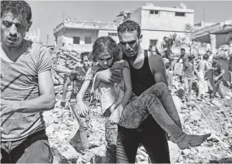  ?? Ahmad Al-msalam / AFP/Getty Images ?? A man carries a child rescued from rubble Tuesday after Syrian and Russian airstrikes in the rebel-held town of Nawa in southern Syria. About 45,000 people are fleeing the conflict.