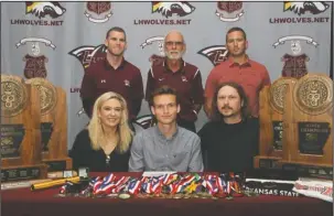  ?? The Sentinel-Record/Richard Rasmussen ?? RUNNING RED: Lake Hamilton’ Cody Weldon, sitting center, signed a national letter of intent to run track and cross country for Arkansas State University Wednesday in the Alumni Room at Wolf Arena. Joining Weldon, in front, from left, were his mother...