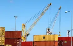  ??  ?? Cranes move shipping containers stacked along the dockside in Bassens, France. France’s economic growth will fall from 2.3 per cent to 1.7 per cent in 2018, the national statistics agency forecasted, adding to the budgetary strains on President...