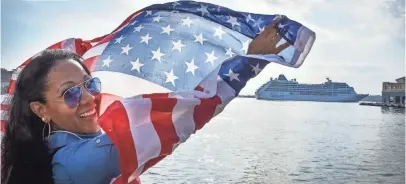  ?? ADALBERTO ROQUE, AFP/GETTY IMAGES ?? A Cuban waves a U.S. flag at the Malecon waterfront as the first USAto-Cuba cruise ship in decades glides into the port of Havana on Monday.