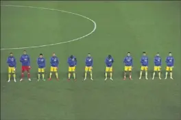  ??  ?? Los jugadores de Kosovo escuchan su himno antes de un partido.
