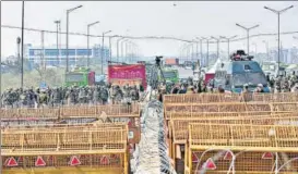  ?? PTI ?? Security personnel stand near barricades ahead of the proposed 'chakka jam' by farmers at Ghazipur border in New Delhi on Saturday.