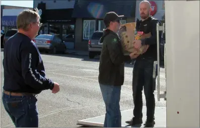  ??  ?? Below left and right: The Drive Away Hunger trailer is unloaded and donations are brought into the Coaldale Food Bank.