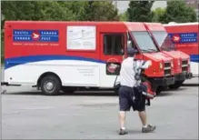  ?? RYAN REMIORZ, THE CANADIAN PRESS ?? Postal worker demands will cost an additional $1 billion, the corporatio­n says. Ottawa has provided a special mediator beginning Friday.