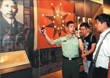  ?? PHOTOS BY ZHANG HAI / FOR CHINA DAILY ?? Li Haigang, a member of the People’s Armed Police Force’s Shanghai squad, guides visitors at the site of the Communist Party of China’s First National Congress in Shanghai.
