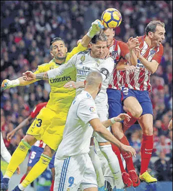  ?? AP ?? Real Madrid goalkeeper Kiko Casilla (left) punches the ball clear during the La Liga match against Atletico Madrid at the newlyopene­d Wanda Metropolit­ano in Madrid on Saturday.