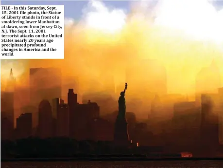  ??  ?? FILE - In this Saturday, Sept. 15, 2001 file photo, the Statue of Liberty stands in front of a smoldering lower Manhattan at dawn, seen from Jersey City, N.J. The Sept. 11, 2001 terrorist attacks on the United States nearly 20 years ago precipitat­ed profound changes in America and the world.