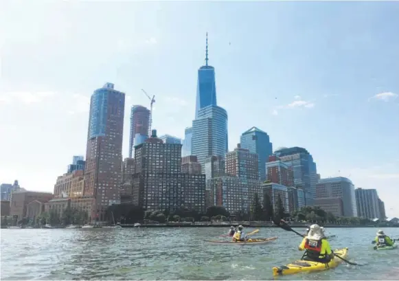  ?? David Brown, Special to The Washington Post ?? Kayakers approach the lower end of Manhattan on the Hudson River, where One World Trade Center dominates the skyline.