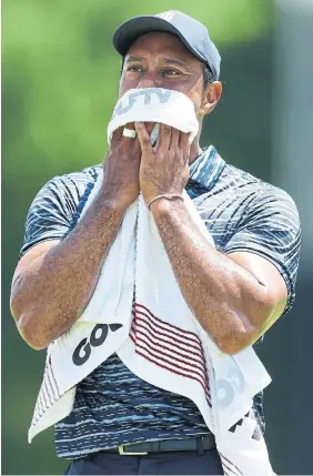  ?? RICHARD HEATHCOTE GETTY IMAGES ?? Tiger Woods was noticeably wincing on most of his shots in his final few holes Thursday, finishing the round nine shots back of leader Rory McIlroy.