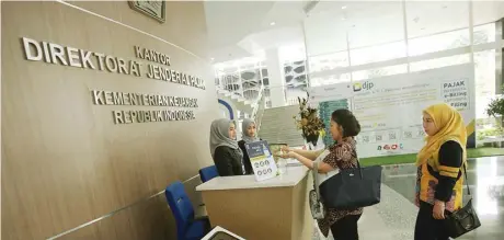  ?? MIFTAHULHA­YAT/JAWA POS ?? SADAR PAJAK: Warga antre di kantor pelayanan pajak untuk melaporkan SPT pada Rabu (11/3). Tersedia hand sanitizer untuk membersihk­an tangan dari kuman.