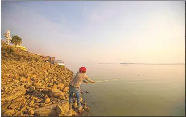  ??  ?? A man fishes off the banks of the Villa Victoria Dam.