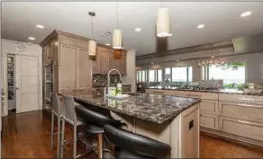  ?? ?? Two islands and stainless-steel appliances provide optimal functional­ity to the kitchen.