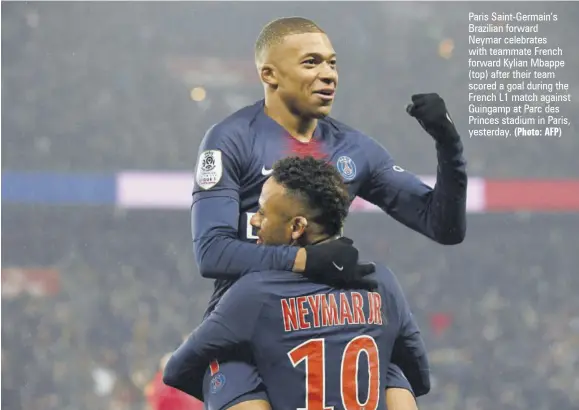  ?? (Photo: AFP) ?? Paris Saint-germain’s Brazilian forward Neymar celebrates with teammate French forward Kylian Mbappe (top) after their team scored a goal during the French L1 match against Guingamp at Parc des Princes stadium in Paris, yesterday.