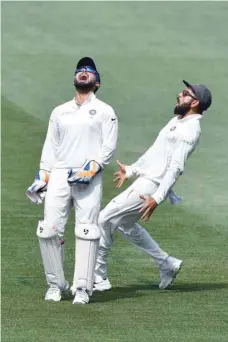  ?? — AFP ?? India’s wicket-keeper Rishabh Pant (left) and captain Virat Kohli celebrate the dismissal of Australia’s Marcus Harris during day four of the first Test at the Adelaide Oval in Adelaide on Sunday.