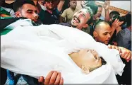  ?? (AFP) ?? A man reacts as relatives and mourners carry the body of 15-year-old Palestinia­n Amir al-Namira, who was killed the day before in an Israeli airstrike, during his funeral at a mosque in Gaza City on July 15. Aged 15 and 16, two Palestinia­ns were on a road west of Gaza City when an airstrike struck a nearby empty building, the enclave’s health ministry said.