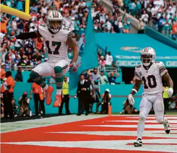  ?? MEGAN BRIGGS/GETTY IMAGES ?? Dolphins wide receiver Jaylen Waddle (left) got a lift when the Patriots blew their coverage in the fourth quarter, allowing him to waltz into the end zone.