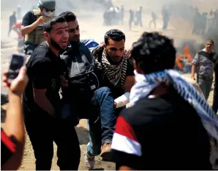  ?? (Mohammed Salem, Ronen Zvulun/Reuters) ?? A WOUNDED Palestinia­n is evacuated during Monday’s border attack in Gaza. Right, Prime Minister Benjamin Netanyahu, his wife, Sara Netanyahu, and senior White House advisers Jared Kushner and Ivanka Trump applaud during the dedication ceremony of the US Embassy in Jerusalem. ‘We continue to find that we do not know how to deal with bad pictures.’