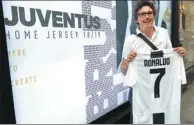  ??  ?? A fan poses with the first official Juventus jersey printed with Cristiano Ronaldo’s name and number in Turin.