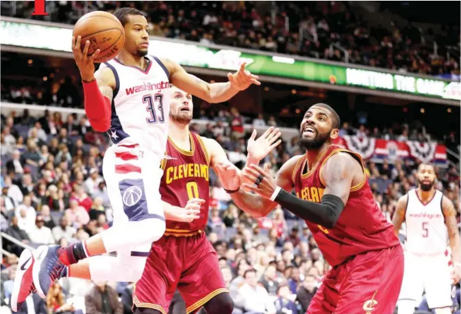  ??  ?? WASHINGTON: Trey Burke #33 of the Washington Wizards looks to make a pass in front of Kyrie Irving #2 of the Cleveland Cavaliers during the second half at Verizon Center on Friday in Washington, DC. — AF