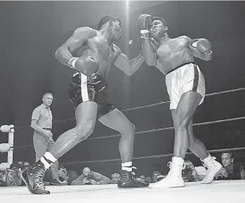  ?? Associated Press ?? In this Nov. 22, 1965, file photo, challenger Floyd Paterson, left, delivers a left hook to the chin of champion Muhammad Ali during the second round of their heavyweigh­t title fight in Las Vegas. Among the questions Jonathan Eig wanted to answer in...