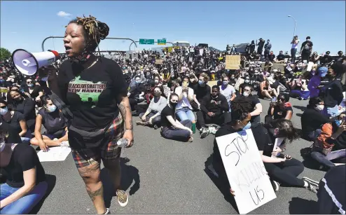  ?? Peter Hvizdak / Hearst Connecticu­t Media ?? Ala Ochumare, founder of New Haven’s Black Lives Matter movement, speaks Sunday to about 1,000 supporters protesting police brutality and the death of George Floyd in Minneapoli­s as they marched in New Haven to the highway, blocking the I-95 and I-91 highways in both directions near the merge in New Haven. As of 5:30 p.m., there were no police confrontat­ions.