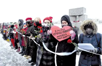  ?? — AFP photo ?? Russian women holding roses and signs form a human chain using Valentine’s Day to express support for the wife of jailed opposition leader Navalny and political prisoners, in Saint Petersburg.