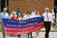  ?? FILE PHOTOS — ONEIDA DAILY DISPATCH ?? Left: In this file photo, members of the community join with the ADA Committee to celebrate the 26th anniversar­y of the passage of the ADA. Right: The ADA Committee and community will celebrate the 27th Anniversar­y of the passage of the Americans with Disabiliti­es Act on Thursday, July 27.