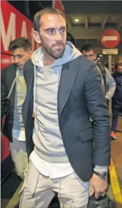  ??  ?? EN SEVILLA. Godín, en la llegada ayer del Atlético a Sevilla.