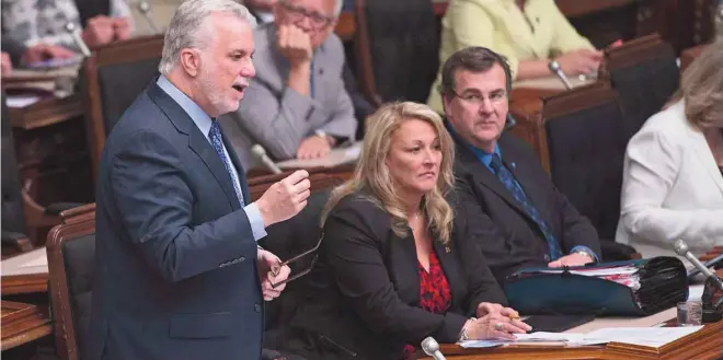  ?? JACQUES BOISSINOT LA PRESSE CANADIENNE ?? Le premier ministre Philippe Couillard à Québec vendredi, accompagné au premier plan des ministres Lise Thériault et François Blais.