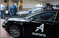  ?? AP/GENE J. PUSKAR ?? Pittsburgh Mayor Bill Peduto checks out autonomous vehicles designed by Aurora Innovation­s (front) and Argo AI after signing an executive order that outlines objectives and expectatio­ns for testing of such vehicles in the city.