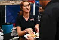  ?? Staff photo by Hunt Mercier ?? ■ Jacey Doyle, a manager at Walk-On’s Bistreaux and Bar, serves a blackened red fish taco Tuesday during Taste of Texarkana at the Four States Fairground­s in Texarkana, Ark.