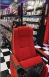  ?? RODNEY HO/RHO@AJC.COM ?? Sant’anselmo bought a movie theater seat to insert in his replica video rental store.