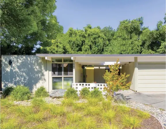  ??  ?? TOP: THIS 1955 FLAT-ROOFED HOME WAS DESIGNED BY A. QUINCY JONES AND FREDERICK E. EMMONS FOR EICHLER HOMES AND IS PART OF AN INTACT EICHLER TRACT IN SACRAMENTO, CALIFORNIA. THE HOMEOWNERS SELECTED A VIBRANT YELLOW FOR THE FRONT DOOR AFTER VISITING A FRIEND’S HOME IN PALM SPRINGS.