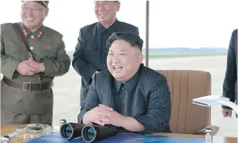  ?? — THE ASSOCIATED PRESS ?? In a photo released by the North Korean government Saturday, leader Kim JongUn looks pleased at what was said to be the test launch of an intermedia­te range Hwasong-12 missile at an undisclose­d location.