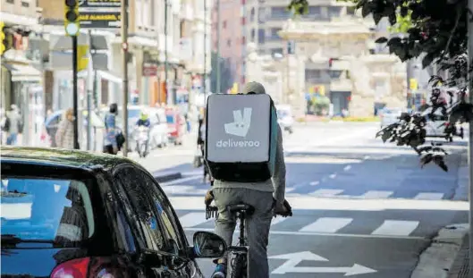  ?? CHUS MARCHADOR ?? Un repartidor en bici de Deliveroo por el centro de Zaragoza, una de las empresas sancionada­s por el uso de falsos autónomos.