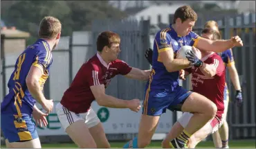  ??  ?? Cillian Kehoe of Gusserane attempts to break away from Castletown duo Richard Farrell and Anthony Masterson.