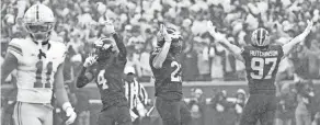  ?? ADAM CAIRNS/COLUMBUS DISPATCH ?? Michigan's Aidan Hutchinson (97), Michael Barrett (23) and defensive back Vincent Gray celebrate as Ohio State receiver Jaxon Smith-njigba walks off the field Saturday.