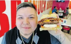  ?? ED KAISER /EDMONTON JOURNAL ?? Jules Thomas, owner of Bannock Burger, displays the signature Big Chief Burger at his restaurant on 124th Street.