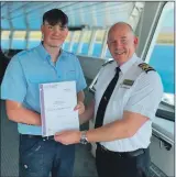  ?? ?? Left: Angus Campbell receives his CalMac Modern Apprentice­ship award from Master Guy Robertson. Right: Craig Evans enjoys interactin­g with passengers on the MV Clansman.